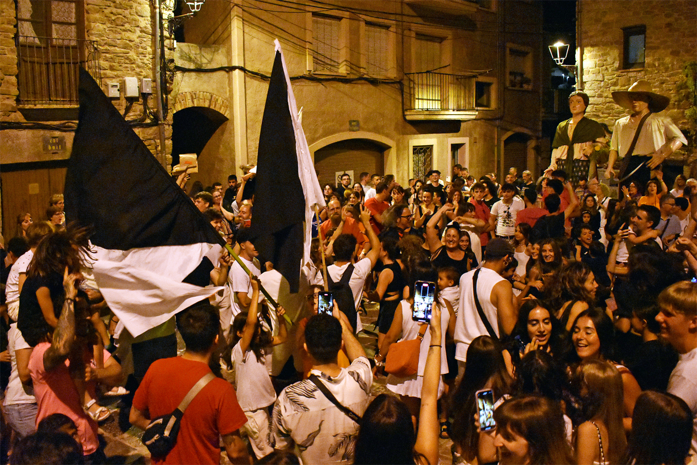 Les banderes dels Bancs i els Negres, després de la reconciliacio, a la plaça Major del Poble Vell durant la Trapellada de la Festa Major de Súria 2024.