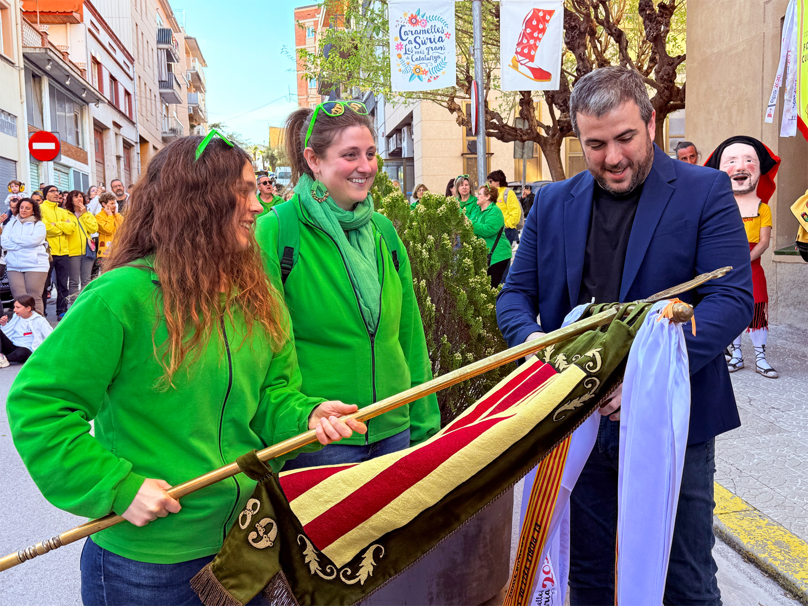 L'alcalde Albert Coberó lliura la cinta commemorativa a la colla de La Llanterna, en l'acte d'inici de les Caramelles de Súria, al davant de la Casa de la Vila.